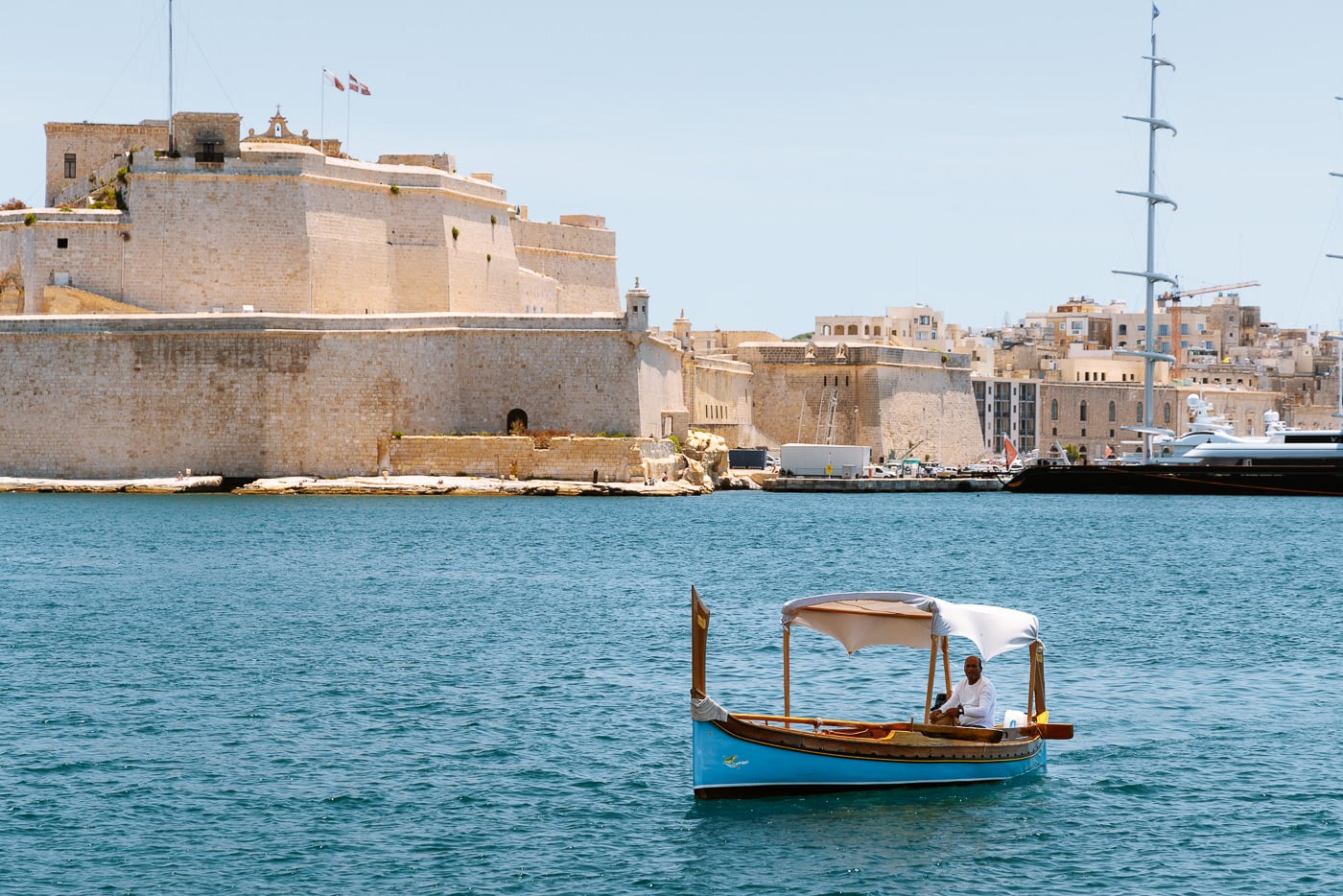 How To Visit The Three Cities Of Malta From Valletta A canopied dgħajsa water taxi on the grand harbour below the bastion walls of fort st angelo in birgu