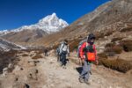 Trekkers in Nepal hiking with a local guide.
