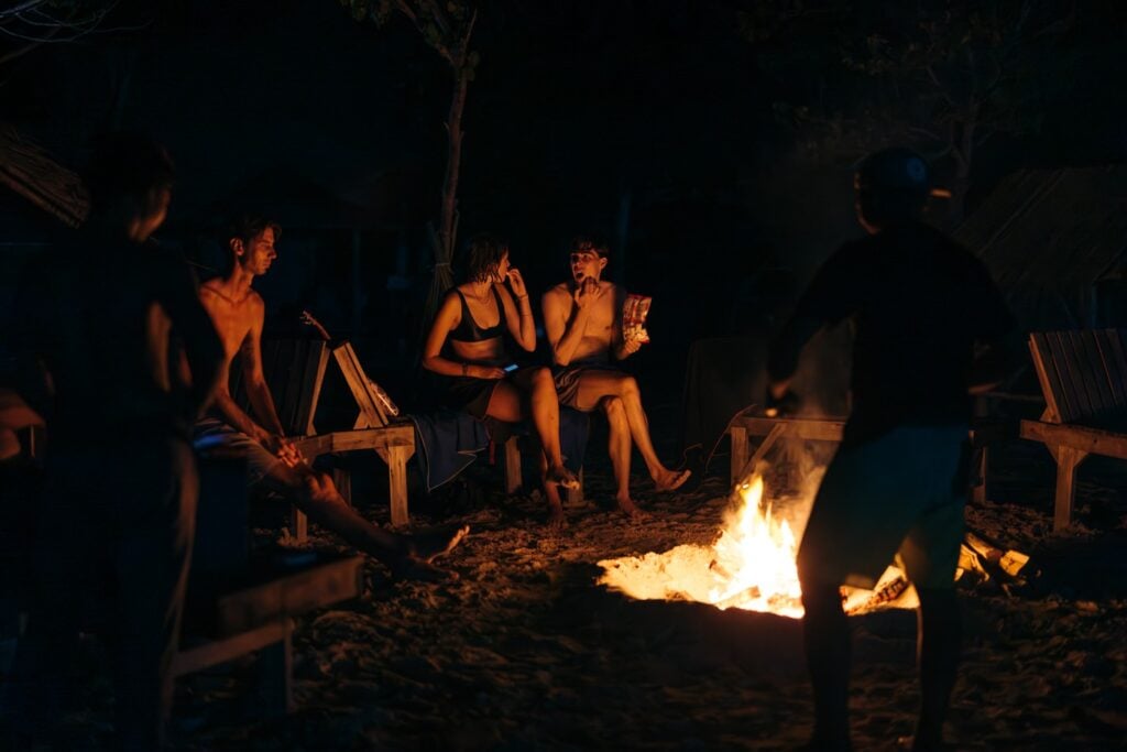 How To Visit &Amp; Camp On Gili Kedis Island In Lombok Travelers around a camp fire on the beach