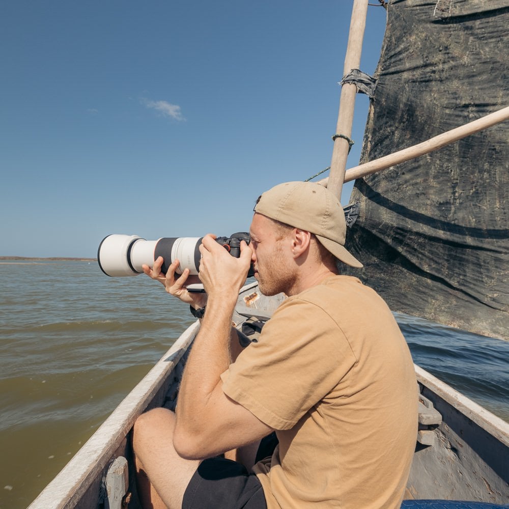 Olly Gaspar taking photos on a small boat