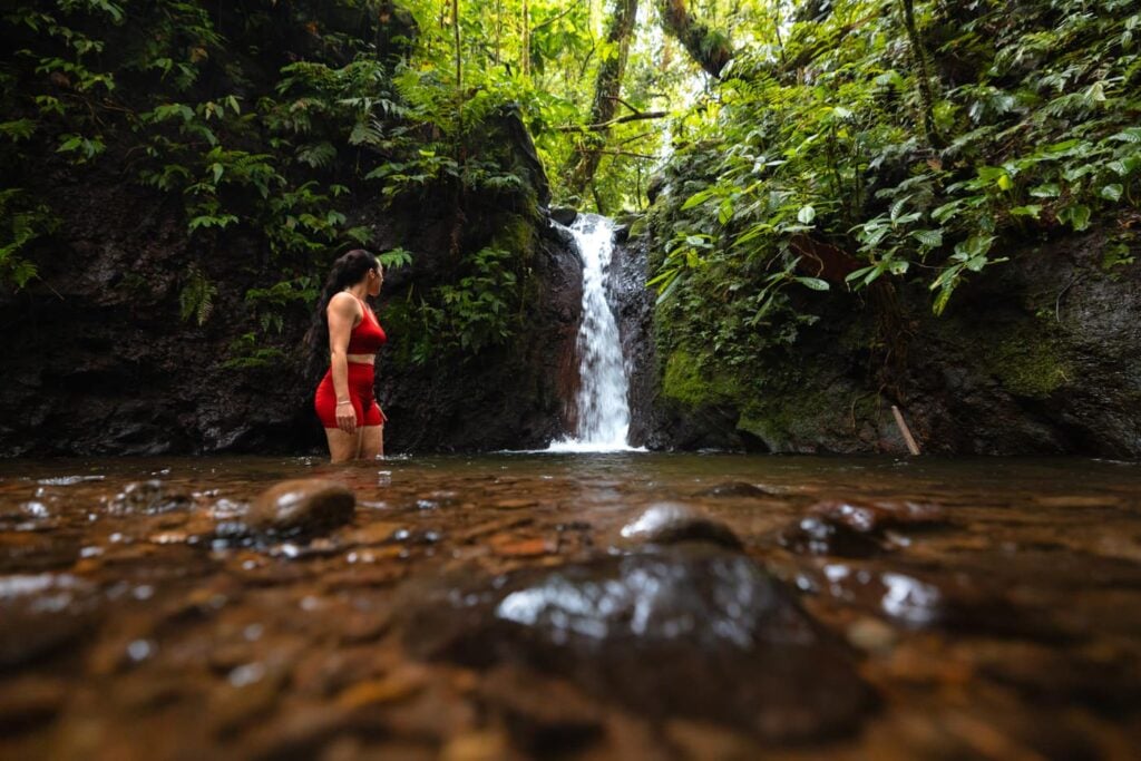 Imbu Rano Lodge: My Experience On Kolombangara Island Girl walking in a waterfall pool on kolombangara island in the solomon islands