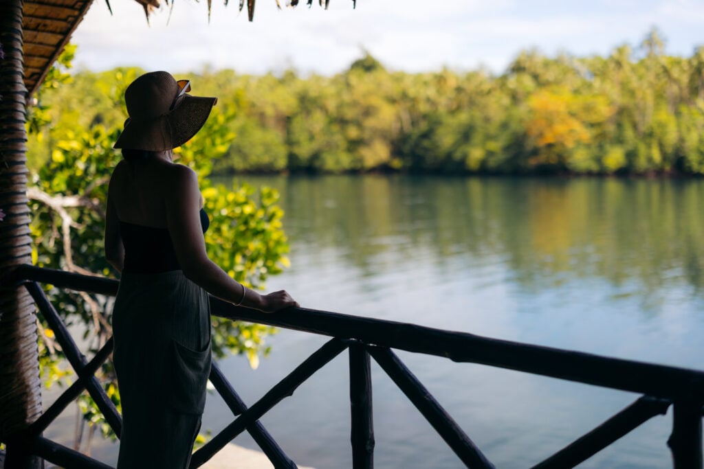 Titiru Eco Lodge Review: Rendova’s Best Local Stay Traveler standing over the water on a bungalow balcony at titiru eco lodge