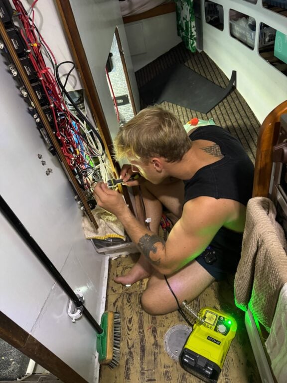 About Olly Gaspar &Amp; We Seek Travel Olly working on an electrical board