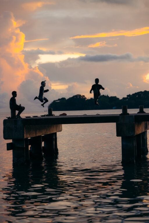 Solomon Islands Eco Lodges &Amp; Dive Resorts Guide Kids jumping from a pier at munda, the solomon islands
