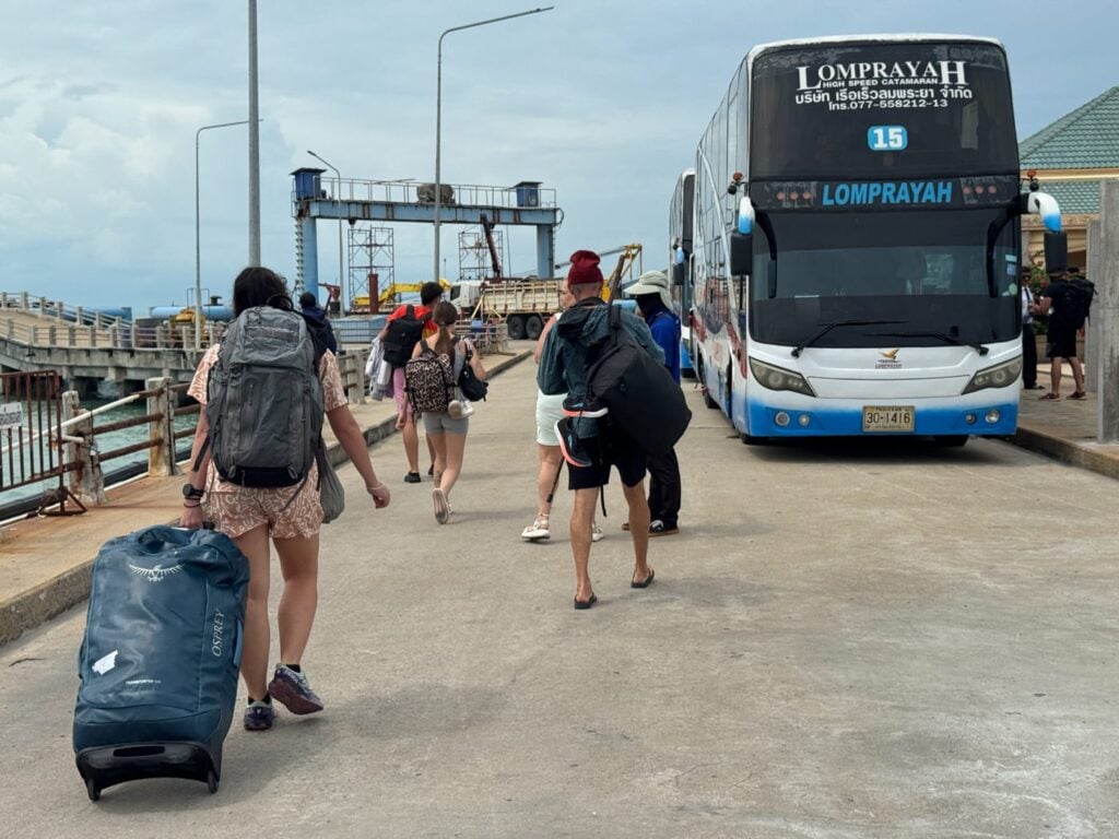 Traveler walking to a bus with heavy bags