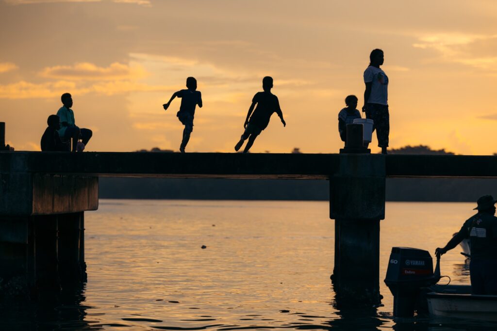 Kids jumping off a wharf in Munda