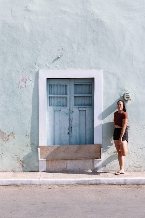 Girl standing beside scenic door in Valladolid, Mexico