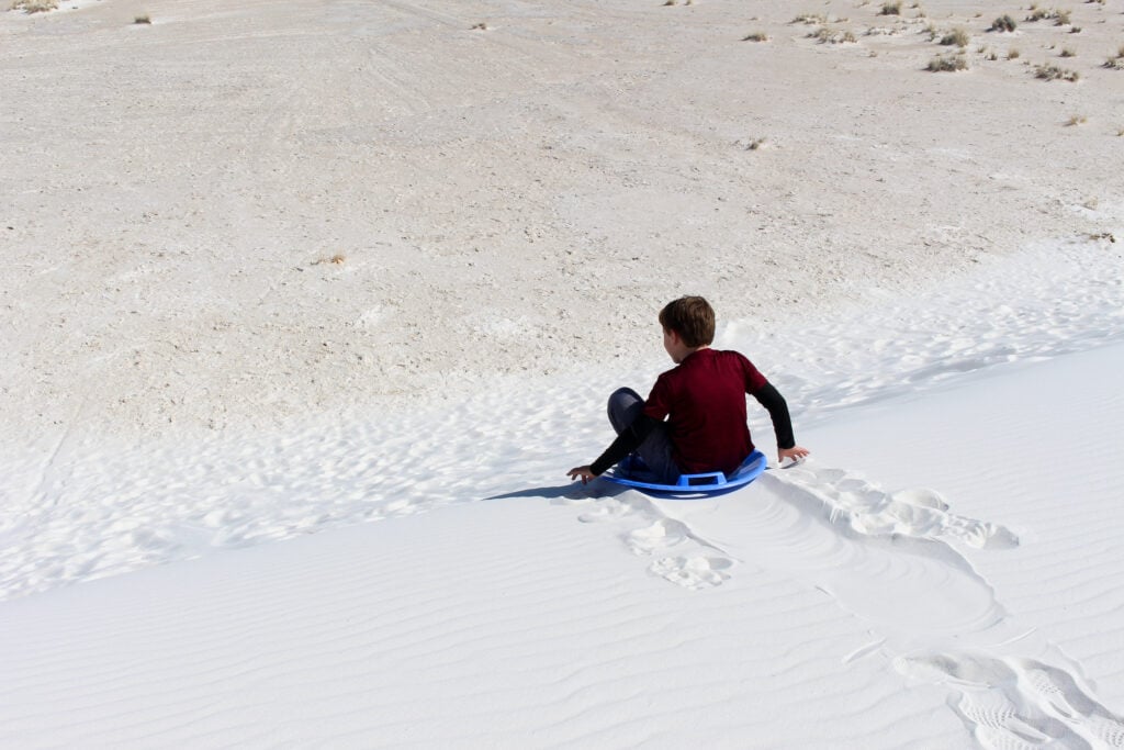 One Day In White Sands: The Perfect Itinerary Sledding on gypsum sand dunes