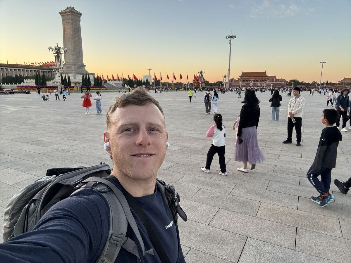 Jambosim Review: Is This Cheap Esim Worth It? (Honest Test) Olly gaspar taking a selfie in tiananmen square at sunset with the monument to the people's heroes behind him