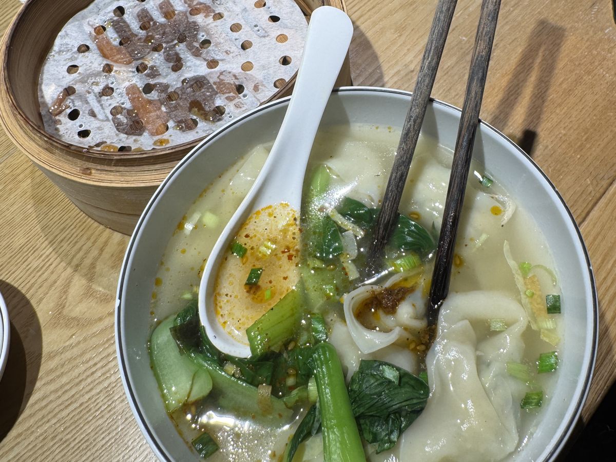 Jambosim Review: Is This Cheap Esim Worth It? (Honest Test) A bowl of wonton soup with greens and chili oil next to a bamboo steamer in beijing